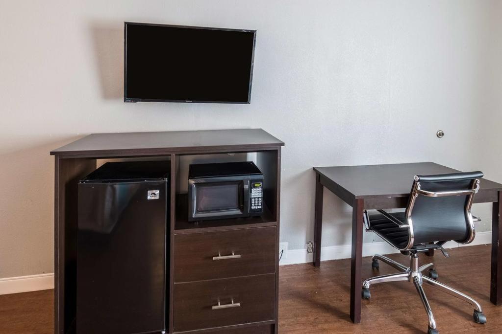 a desk with a microwave and a table with a chair at Econo Lodge in Mineral Wells