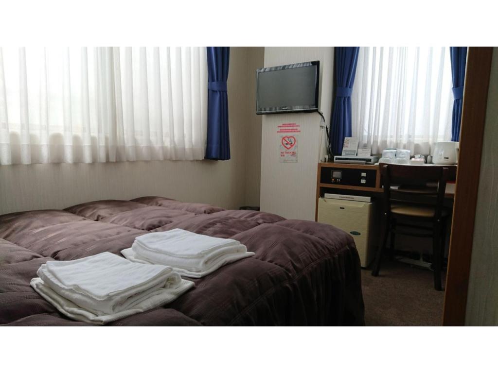 a room with a bed with white towels on it at City Inn Nishi Tanabe / Vacation STAY 78538 in Osaka