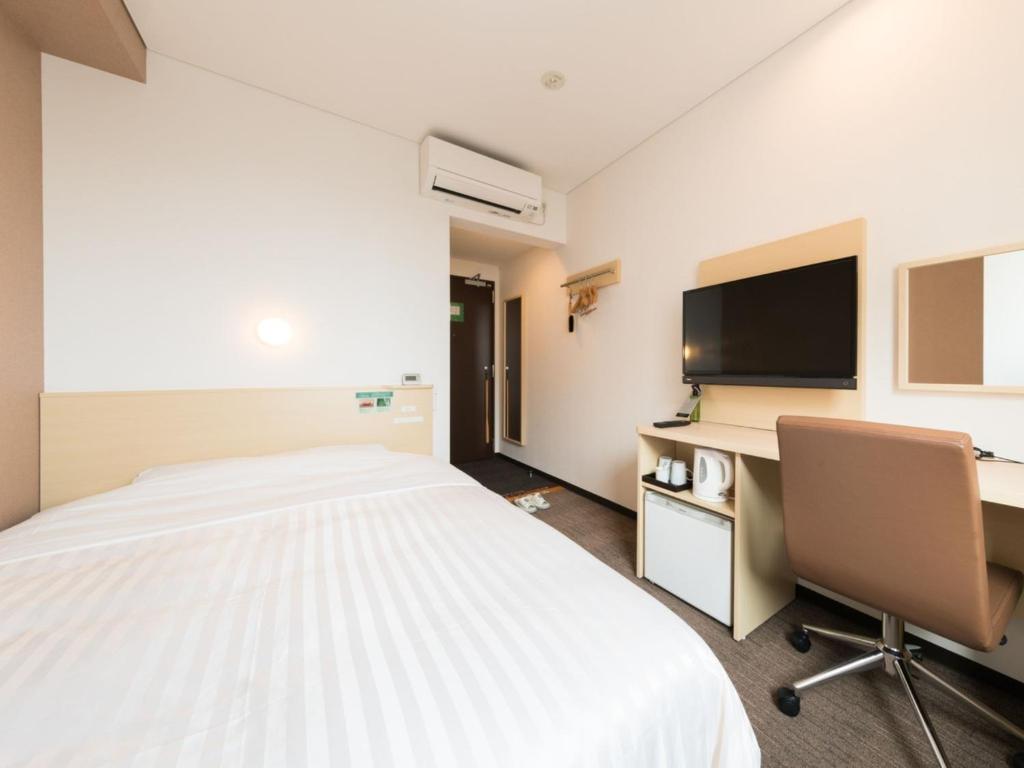 a bedroom with a bed and a desk and a tv at Super Hotel Tokyo Kinshicho Ekimae / Vacation STAY 78884 in Tokyo