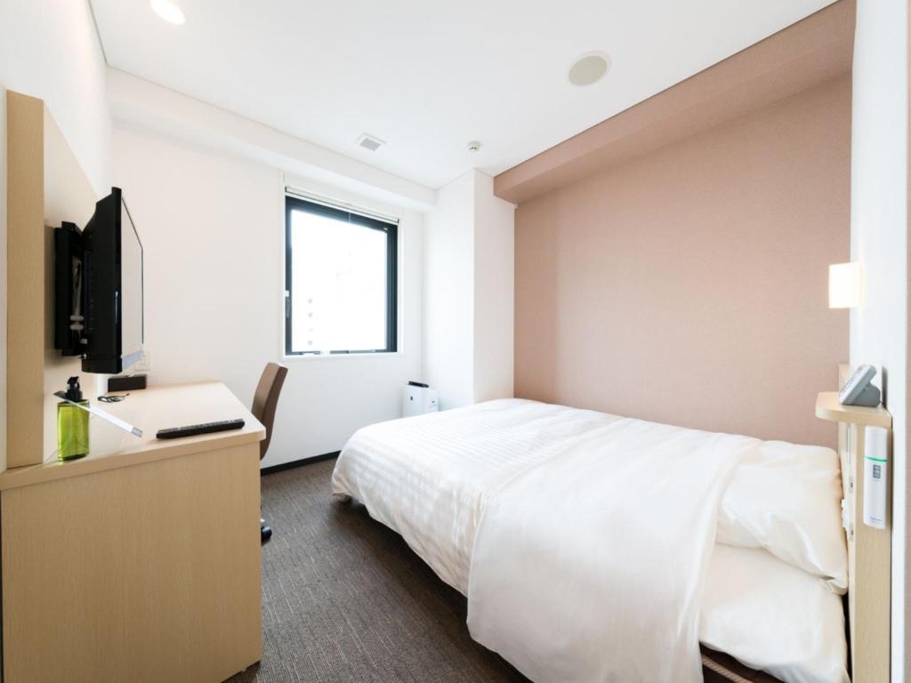 Schlafzimmer mit einem Bett, einem Schreibtisch und einem TV in der Unterkunft Super Hotel Tokyo Kinshicho Ekimae / Vacation STAY 78889 in Tokio