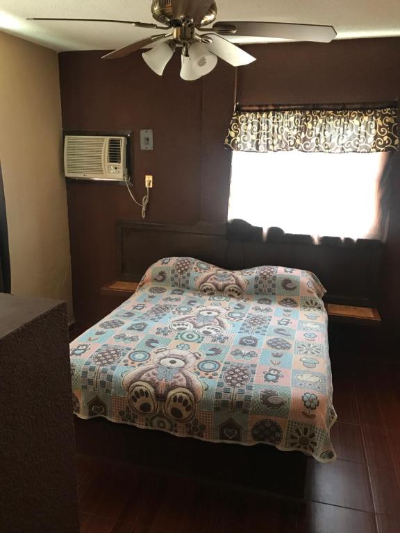 - une chambre avec un lit, un ventilateur et une fenêtre dans l'établissement Hotel San Martín, à Tampico