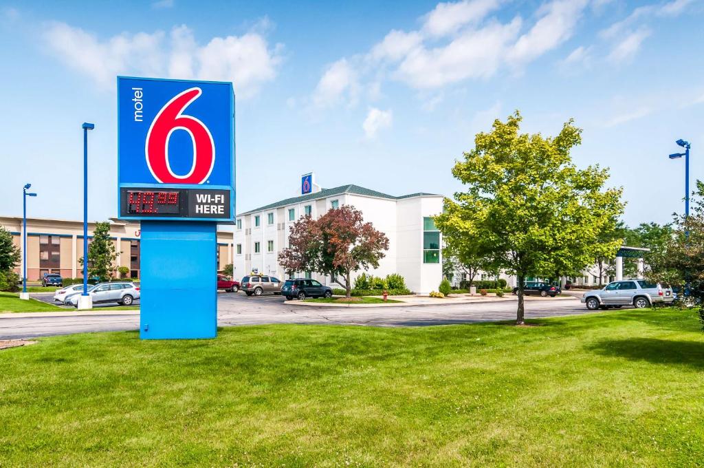 un cartel en el césped frente a un edificio en Motel 6-Joliet, IL - Chicago - I-55, en Joliet