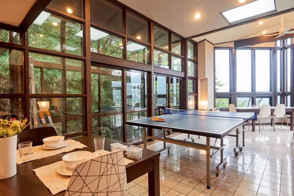 a ping pong table in a room with windows at Chalet Itomic M in Hakone