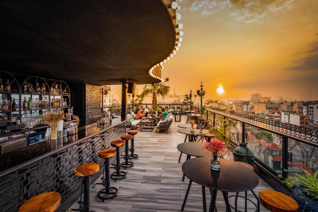 a bar with a view of the city at sunset at Solaria Hanoi Hotel in Hanoi