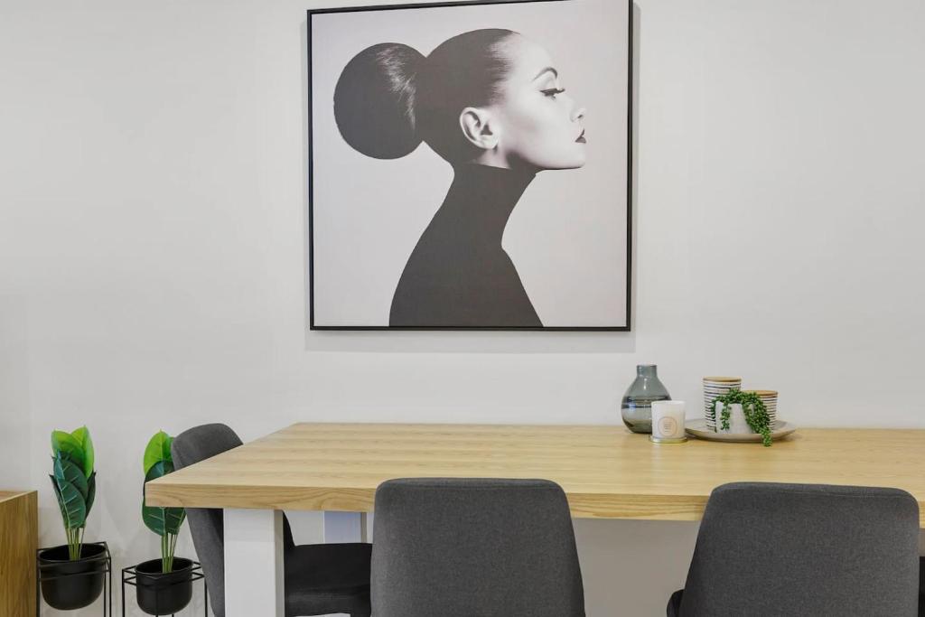 a dining room with a table and a picture on the wall at YARRA · YARRA Toorak Rd & Chapel St. Pool, Gym & Parking in Melbourne