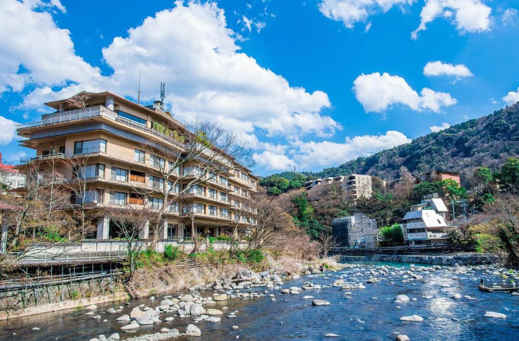 ein Gebäude neben einem Fluss mit Felsen in der Unterkunft Hakone Yumoto Onsen Hotel Kajikaso in Hakone