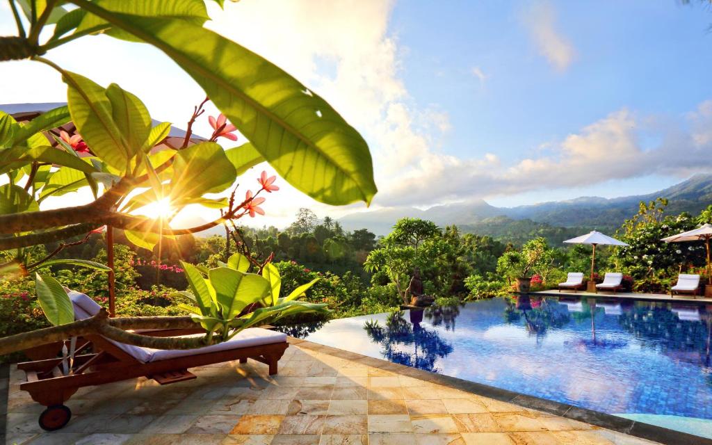 un complejo con piscina y montañas de fondo en Shanti Natural Panorama View Hotel en Singaraja