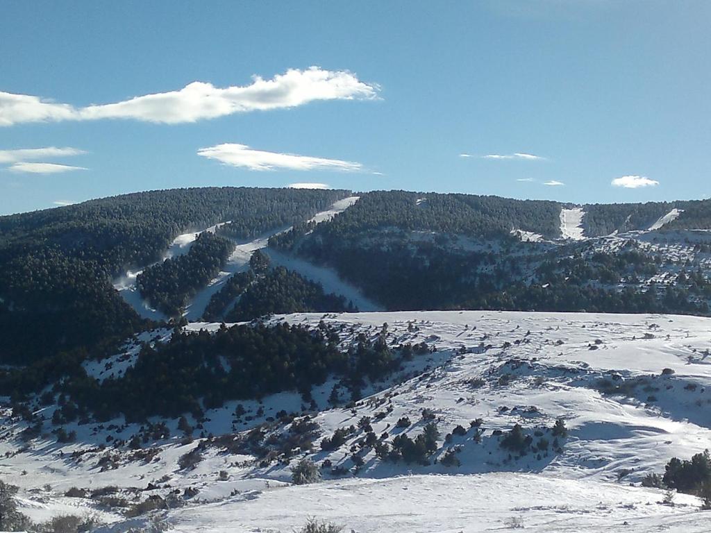 vistas a una montaña cubierta de nieve con árboles en Apartamentos Vicenta, en Valdelinares