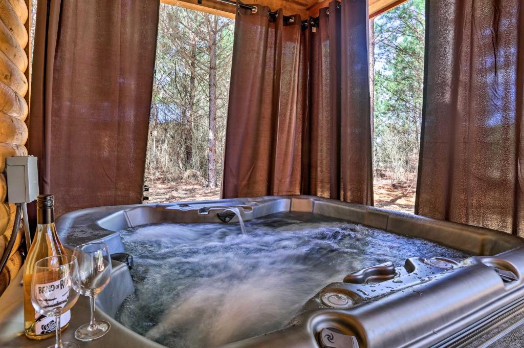 a bath tub in a room with a window at The Breeze Forested Oasis with Hot Tub and Deck! in Broken Bow