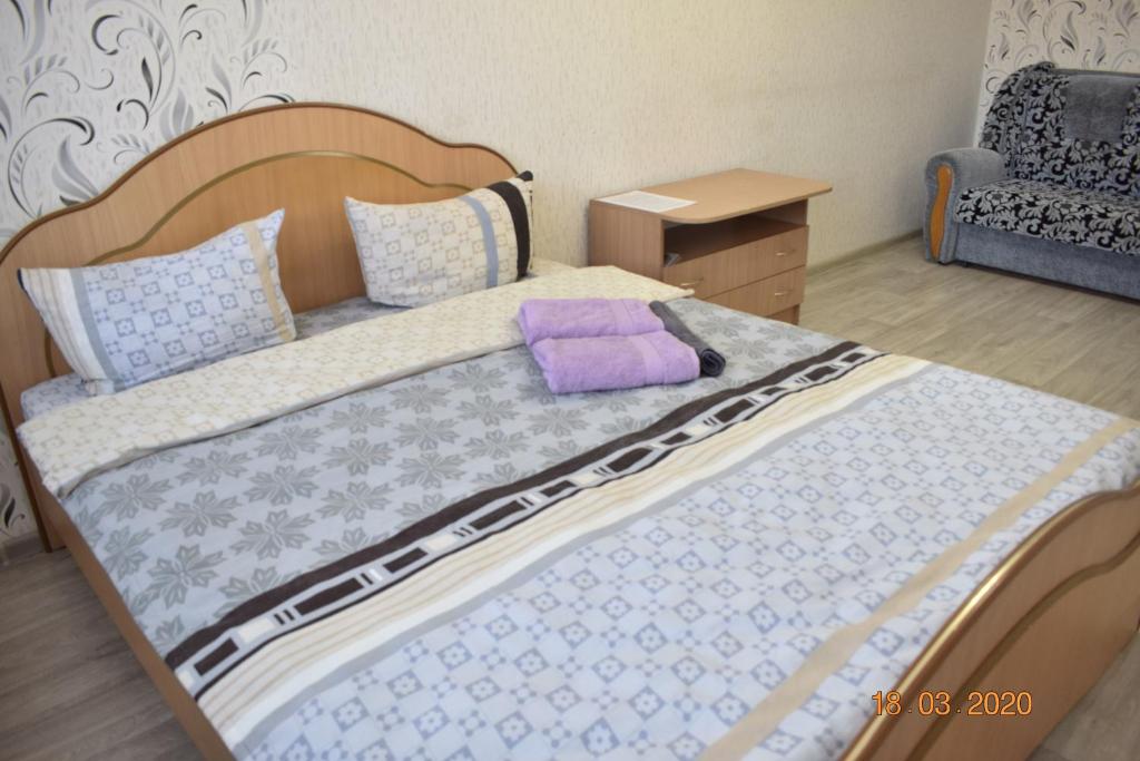 - une chambre avec un lit et un oreiller violet dans l'établissement 1 комнатные апартаменты на Ауэзова 236, à Kökşetaw