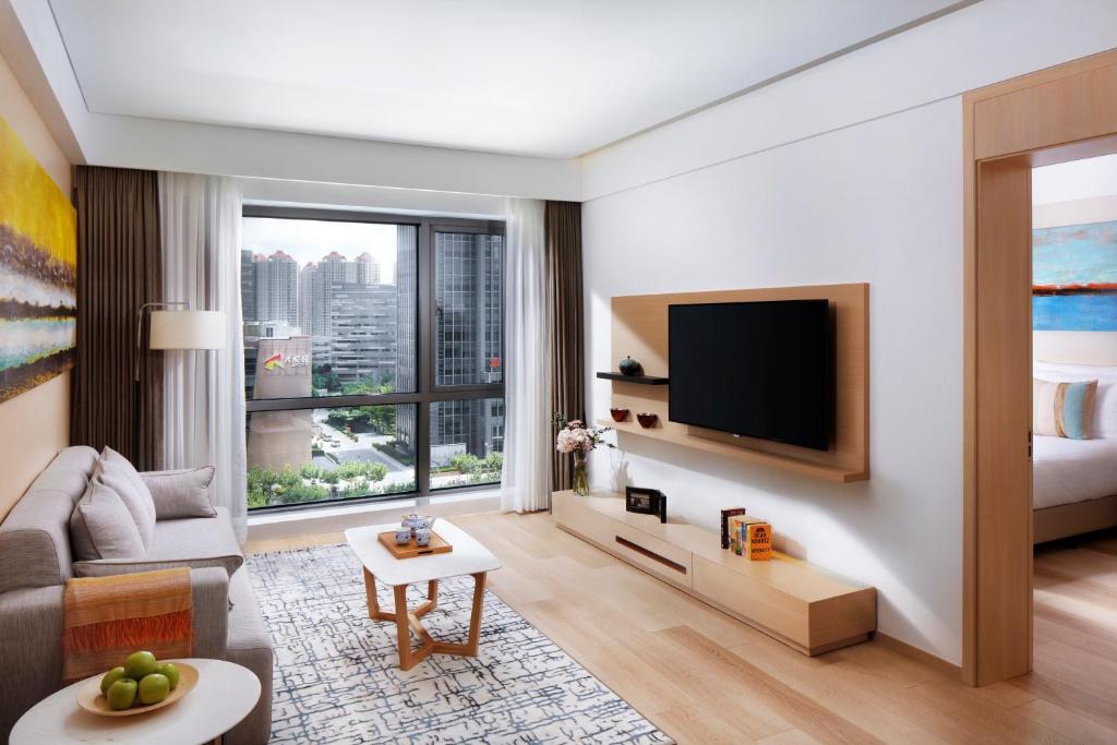 a living room with a couch and a tv at Sincere Residence Changfeng - Changfeng Ecological Business District - Near Exit 3 of Changfeng Park Station on Subway Line 15 in Shanghai