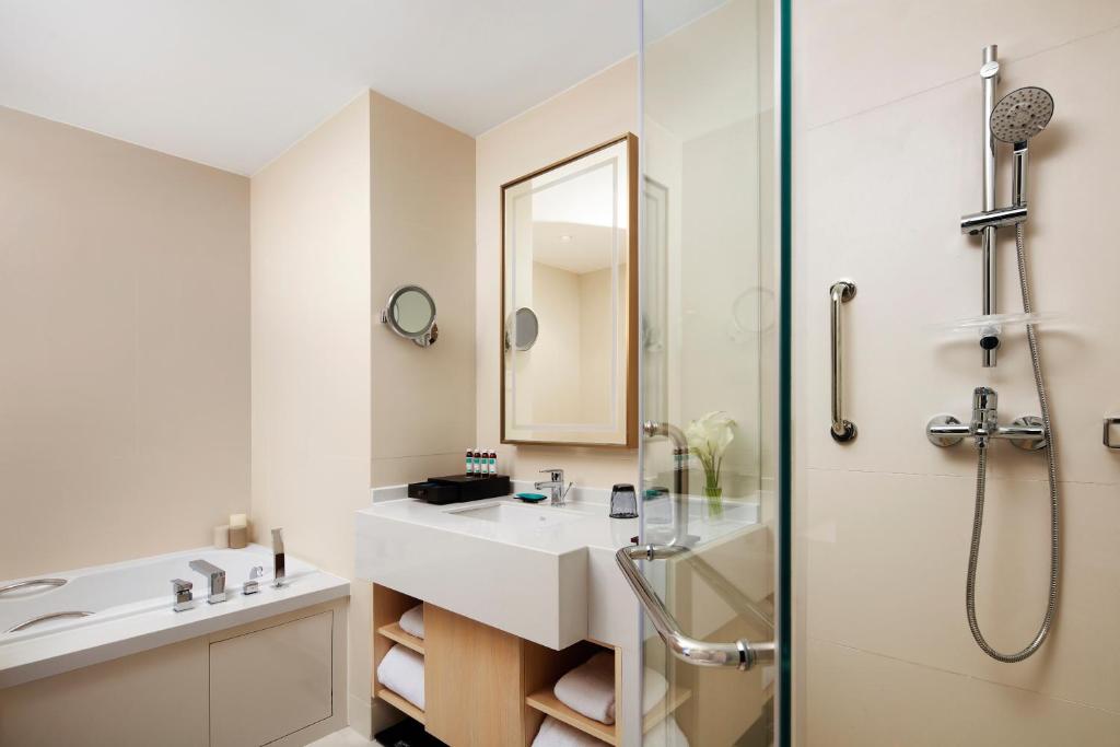 a white bathroom with a sink and a shower at Sincere Residence Changfeng - Changfeng Ecological Business District - Near Exit 3 of Changfeng Park Station on Subway Line 15 in Shanghai