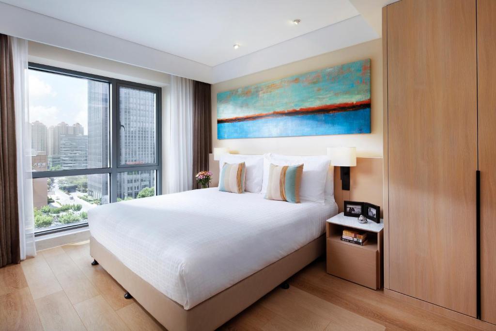 a bedroom with a large bed and a large window at Sincere Residence Changfeng - Changfeng Ecological Business District - Near Exit 3 of Changfeng Park Station on Subway Line 15 in Shanghai