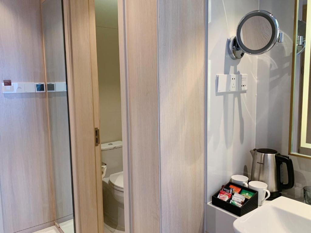 a bathroom with a toilet and a mirror and a sink at Sincere Residence Changfeng - Changfeng Ecological Business District - Near Exit 3 of Changfeng Park Station on Subway Line 15 in Shanghai