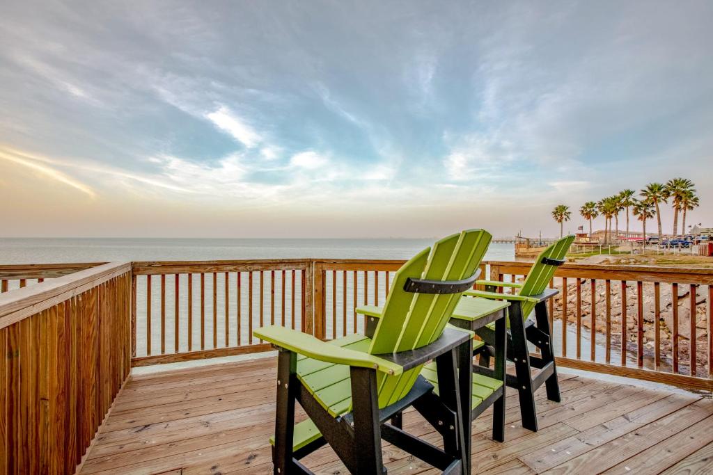 2 sillas verdes en una terraza con la playa en Bayview Paradise, en Port Isabel