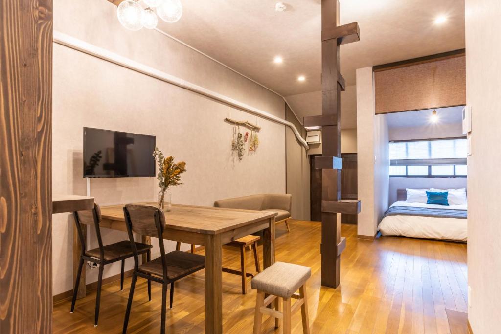 大阪的住宿－ビジュースイーツ Century，一间带桌子和床的用餐室