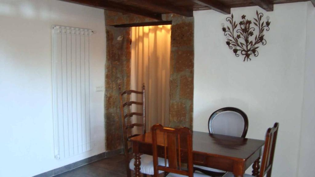 Barbarano Romano的住宿－卡薩里奧公寓，一间带木桌和椅子的用餐室