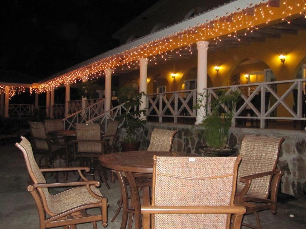 a patio with chairs and a table and lights at Paradise Beach Hotel in Kingstown