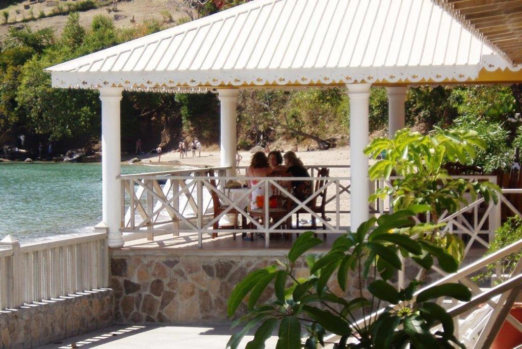 two people sitting at a table in a gazebo at Paradise Beach Hotel in Kingstown