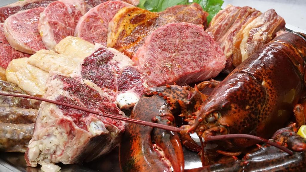 a plate of food with a lobster and other foods at Phoenix Chalets by HHG in Hakuba