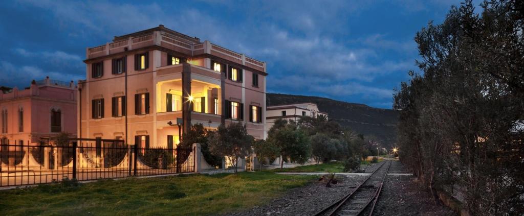 a building next to a train track in front of a building at Hotel Al Gabbiano in Bosa Marina