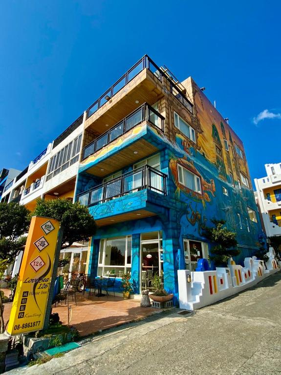 a blue building with a painting on the side of it at LoveSea 126 Beach Inn in Kenting