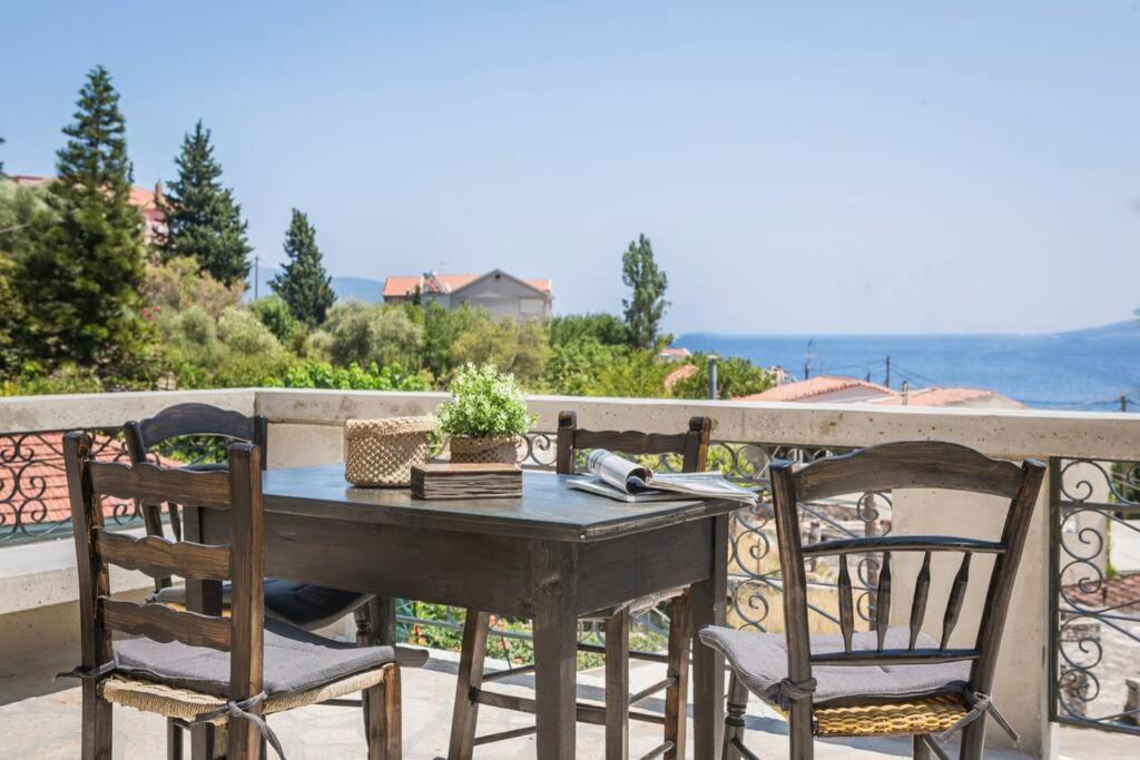 a table and chairs on a balcony with a view of the ocean at la casa di zia Anna Agia Efimia village in Ayia Evfimia