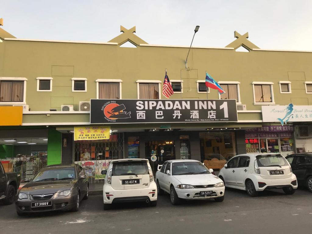 a group of cars parked in front of a building at Sipadan Inn 1 in Semporna