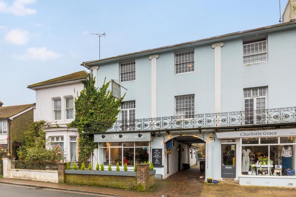 un edificio blanco con balcón en la parte superior en Morleys Rooms - Located in the heart of Hurstpierpoint by Huluki Sussex Stays, en Hurstpierpoint