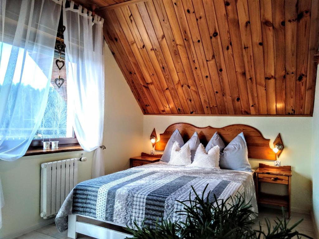 um quarto com uma cama e um tecto em madeira em Jarek em Pobierowo