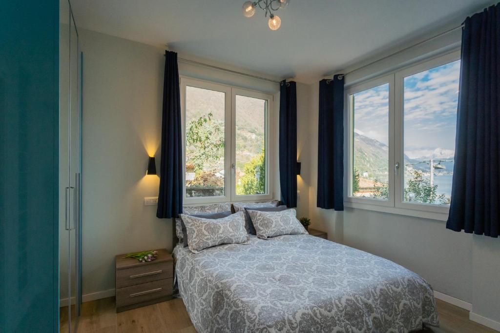 een slaapkamer met een bed en 2 ramen bij Luna & Stella Apartments by Rent All Como in Argegno