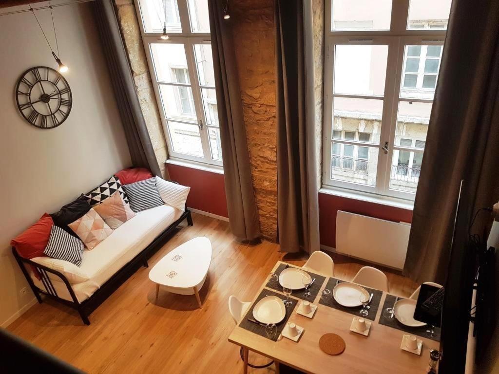 een woonkamer met een bank en een tafel bij Cosy appartement, dans les pentes de la Croix Rousse in Lyon