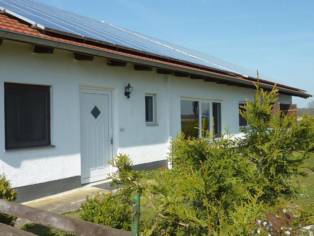 a white house with solar panels on it at Ferienhaus Ainsen in Bad Füssing