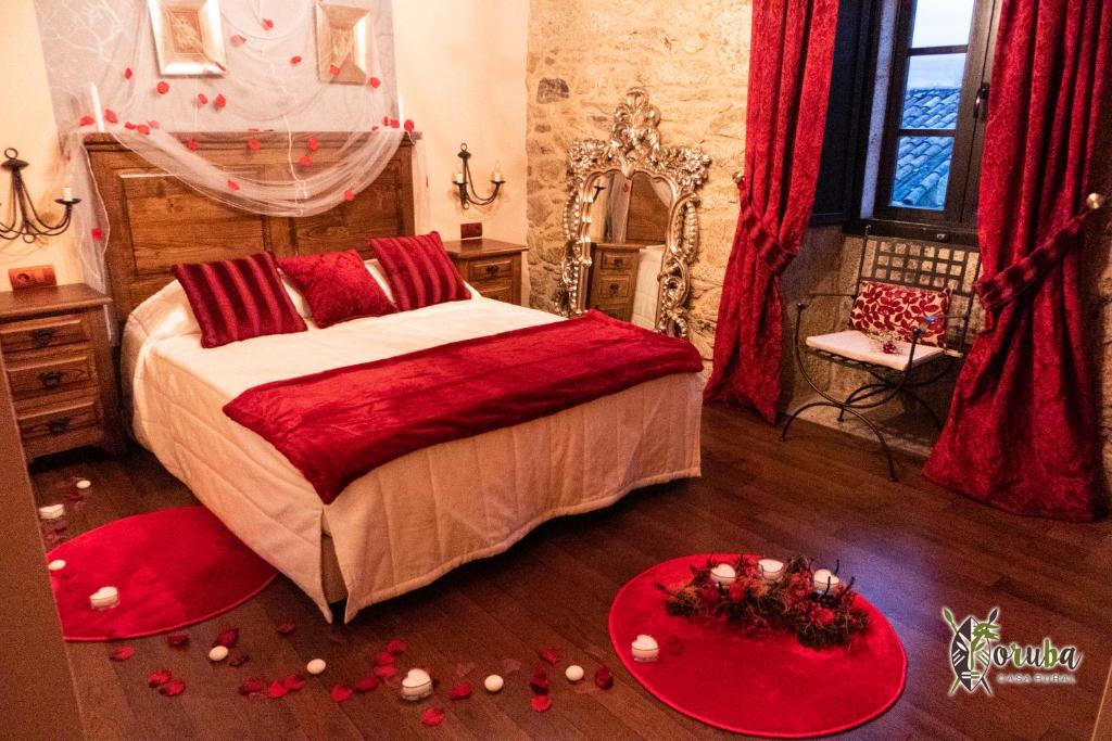 a bedroom with a bed with red pillows and red decorations at Casa Rural Yoruba in Amés