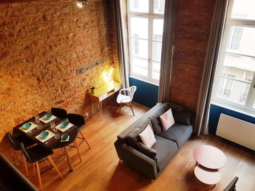 een woonkamer met een bank en een tafel bij Charmant appartement style Canut Pentes Croix Rousse in Lyon
