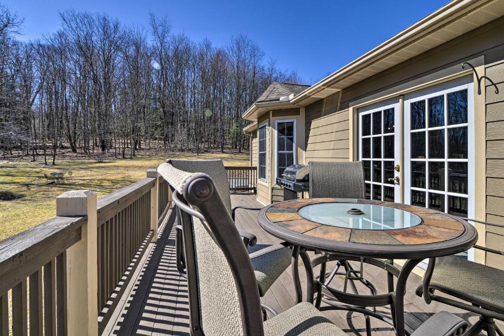 um pátio com uma mesa e cadeiras num deque em Private Family Home with Deck, Porch and Forest Views! em McComas Beach