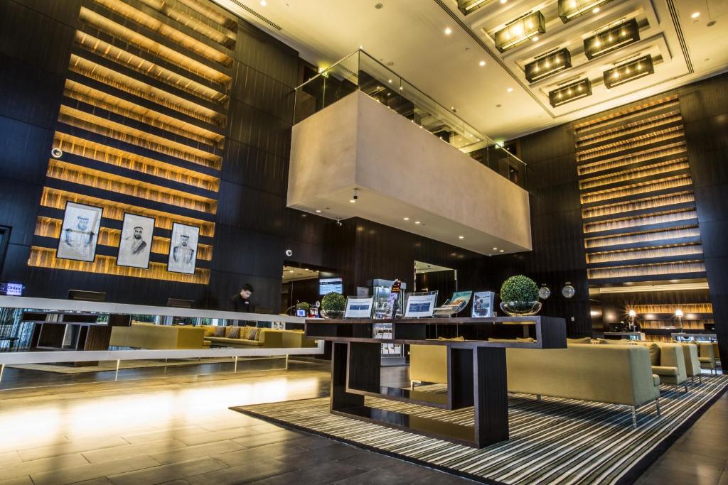 a lobby of a hotel with a bar and couches at Centro Yas Island-by Rotana in Abu Dhabi