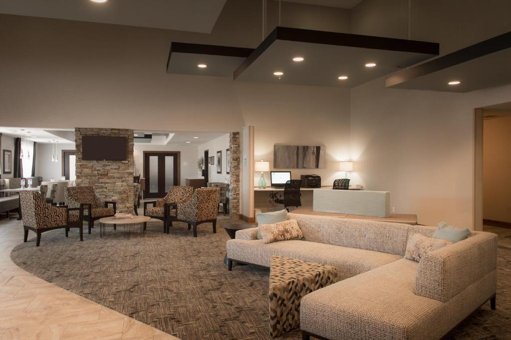 a living room with couches and chairs and a fireplace at Holiday Inn Express Le Claire Riverfront-Davenport, an IHG Hotel in Le Claire