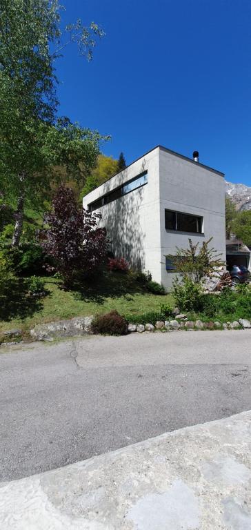 um edifício branco na berma de uma estrada em Casa 21 em Sonogno