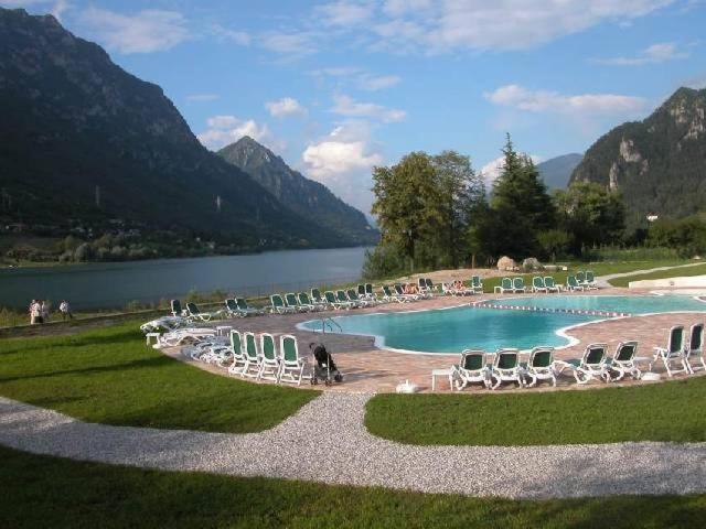 a large swimming pool with chairs and a lake at Vico Large + Sweet in Crone