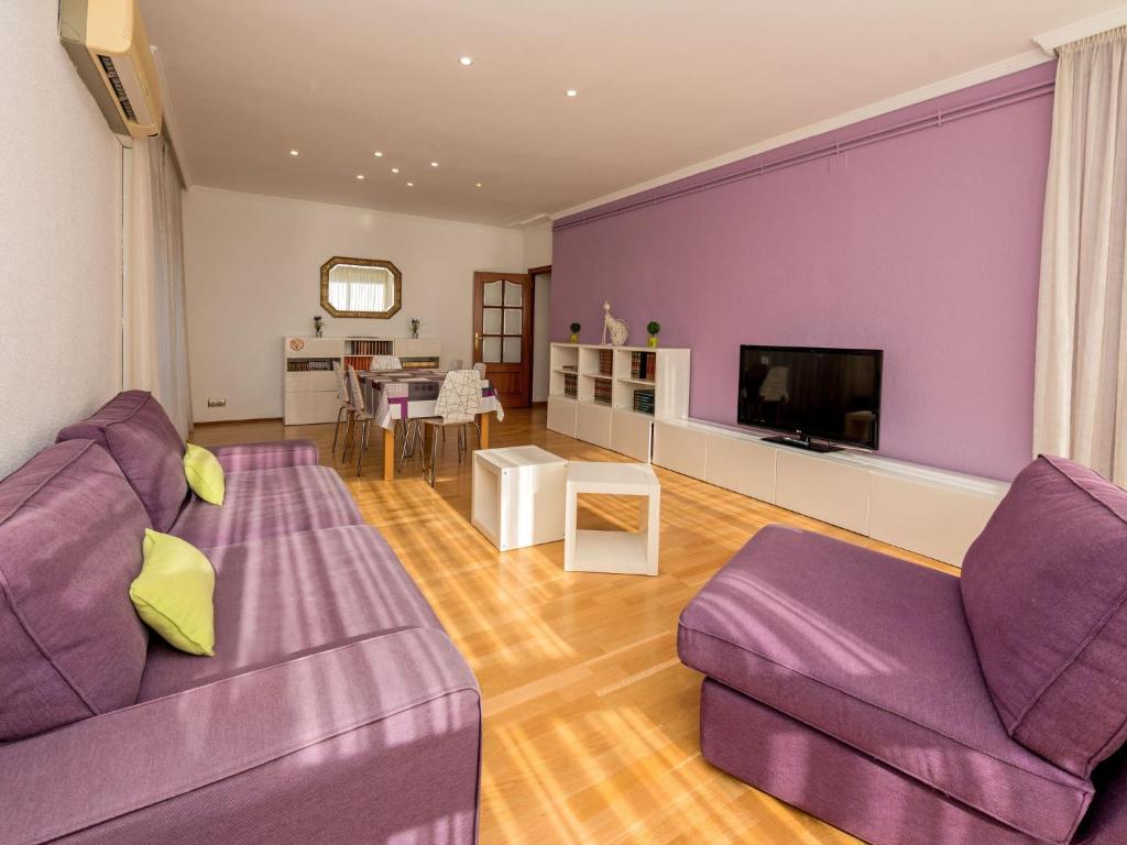 un soggiorno con mobili viola e una parete viola di Apartment Sants-Les Corts Galileu by Interhome a Barcellona