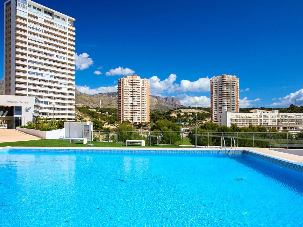 a large blue swimming pool with buildings in the background at Apartment Terramar in Benidorm