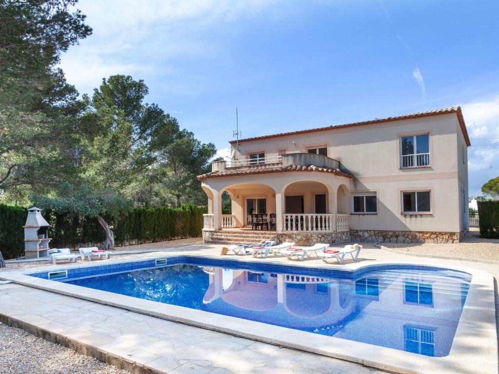 a villa with a swimming pool in front of a house at Villa Villa Alguer by Interhome in Les tres Cales