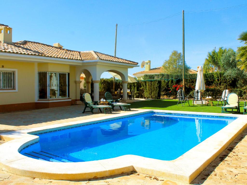 a swimming pool in front of a house at Holiday Home Bonalba Golf- Urb- Los Naranjos by Interhome in Muchamiel
