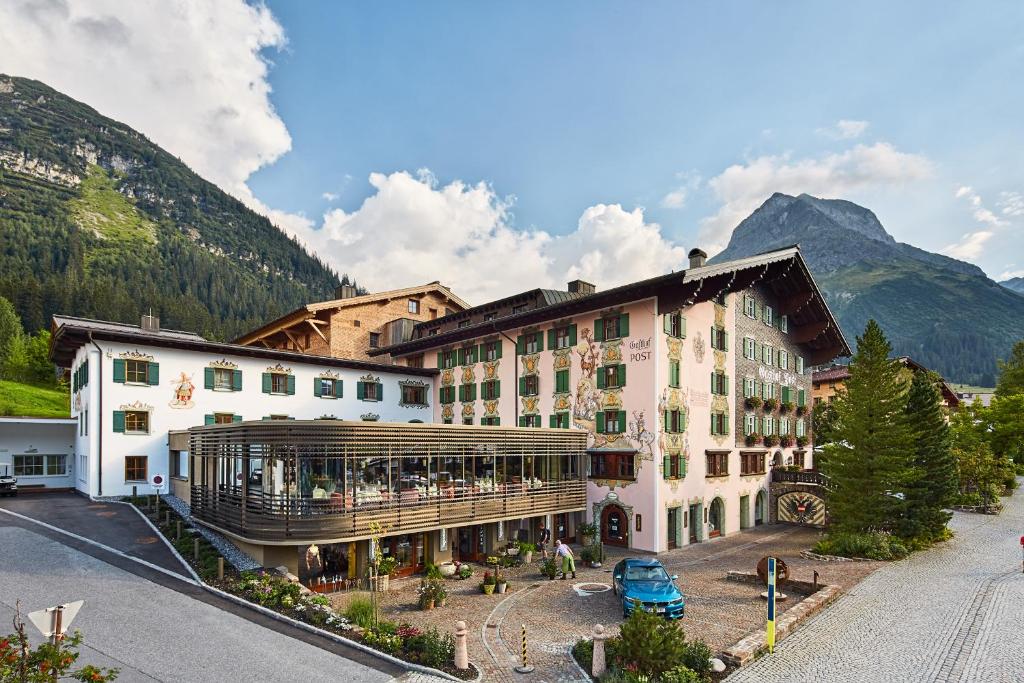 a hotel in the mountains with mountains in the background at Post Lech Arlberg in Lech am Arlberg