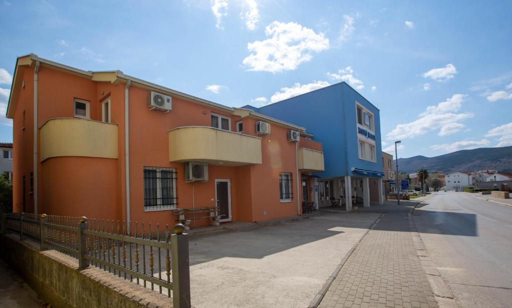 une rangée de bâtiments colorés dans une rue dans l'établissement Pansion Boris, à Međugorje