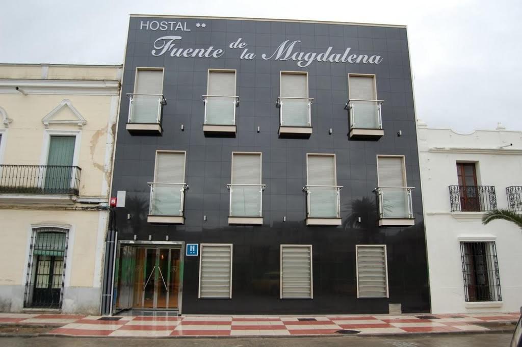 un edificio negro con un cartel en el costado en Fuente de la Magdalena, en Santa Amalia