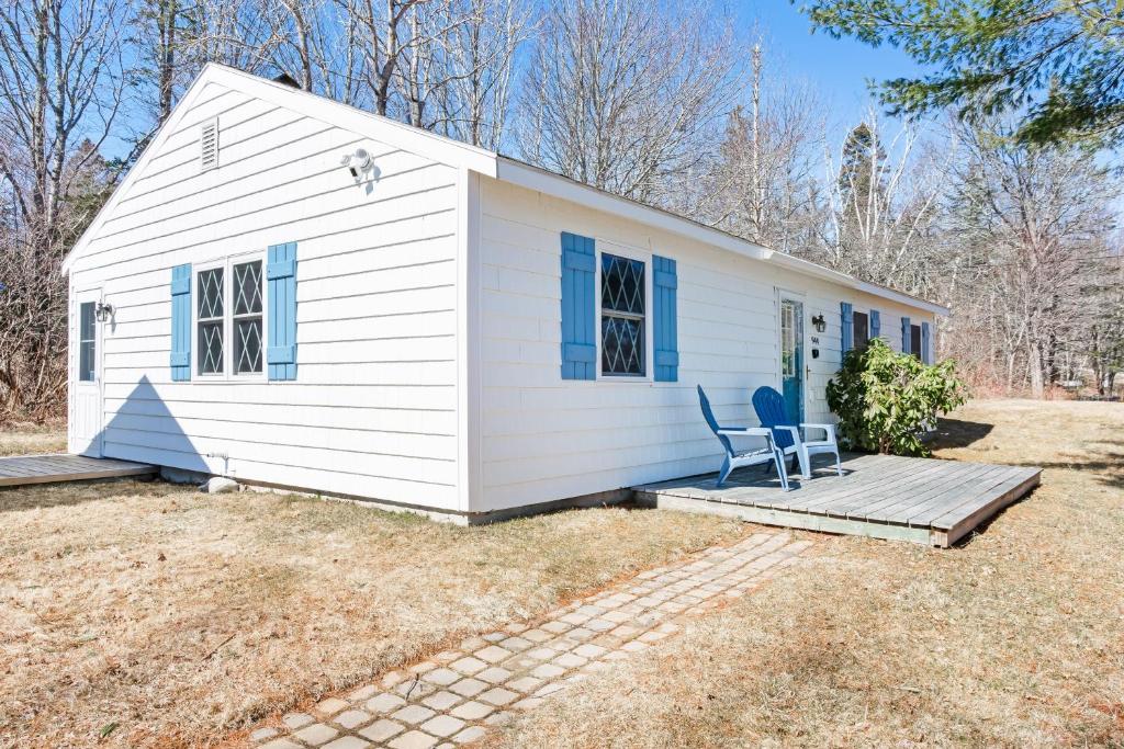 una casa bianca con una sedia su un portico di Lucky Stone Cottage a Tremont
