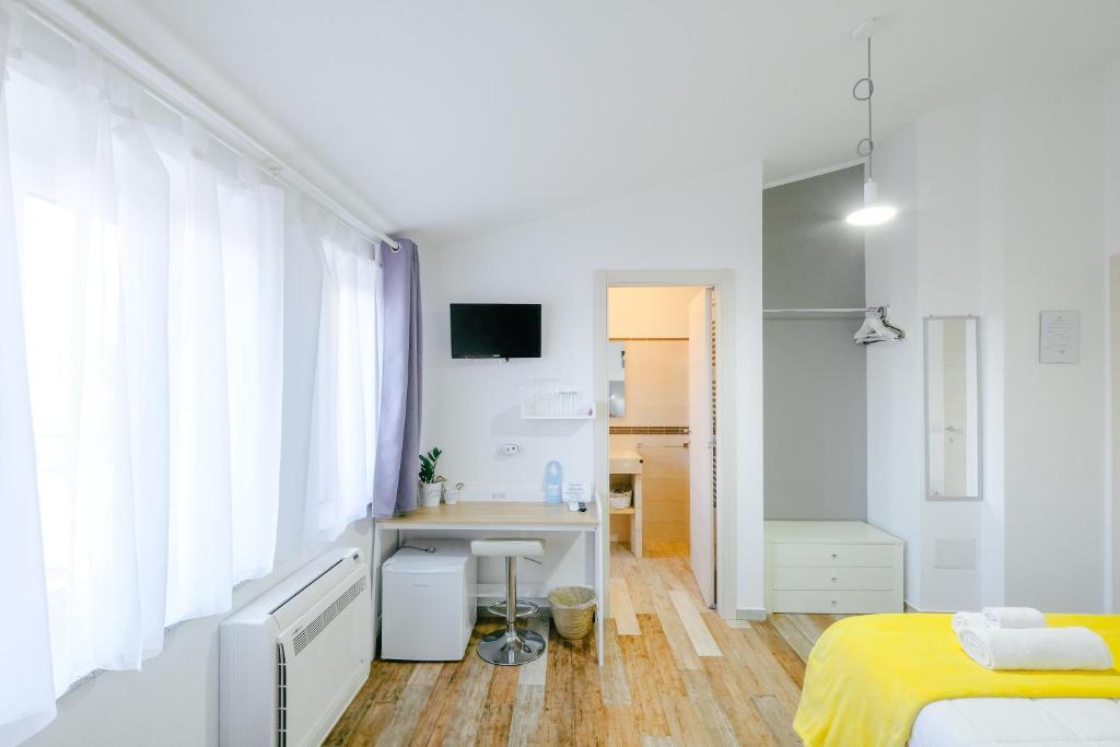 1 dormitorio con cama, escritorio y lavamanos en B&B Fradama' Holiday, en Dorgali