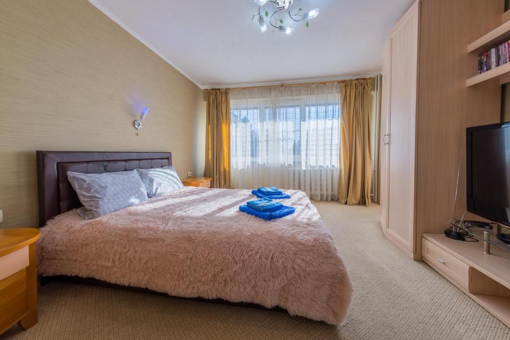 a bedroom with a large bed and a flat screen tv at Апартаменты рядом с вокзалами Сочи in Sochi